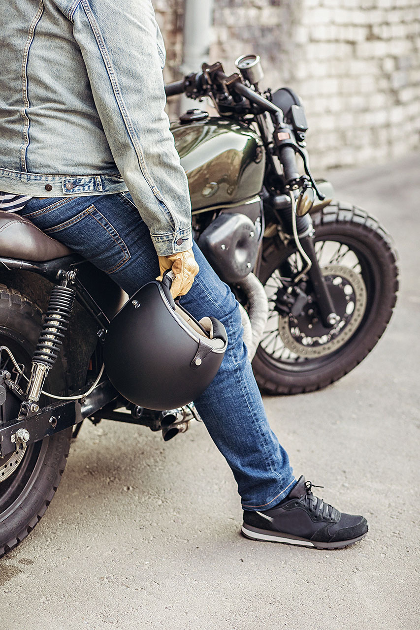 Motorrad Fahrer hält seinen Helm fest